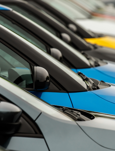 Vehicles for sale parked in a row with close up detail on the wing mirror without focus on any particular model making the cars generic and unidentifiable. A good concept for general car sales where a range of different manufacturers are on offer.